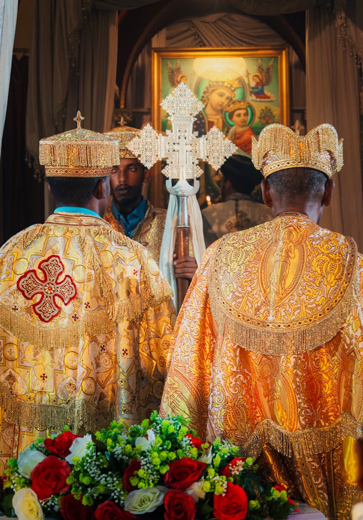 Ethiopian Orthodox priests in ceremonial attire holding a cross during a religious service.